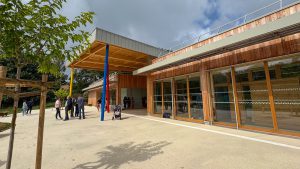 Photo du batiment construit pour les primaires à Charnay avec une ossature bois, des personnes aux second plan