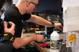 Un monsieur répare un ordinateur