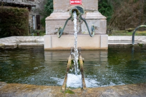 Un robinet d'une fontaine à Nans dans le Doubs avec le panneau eau non potable
